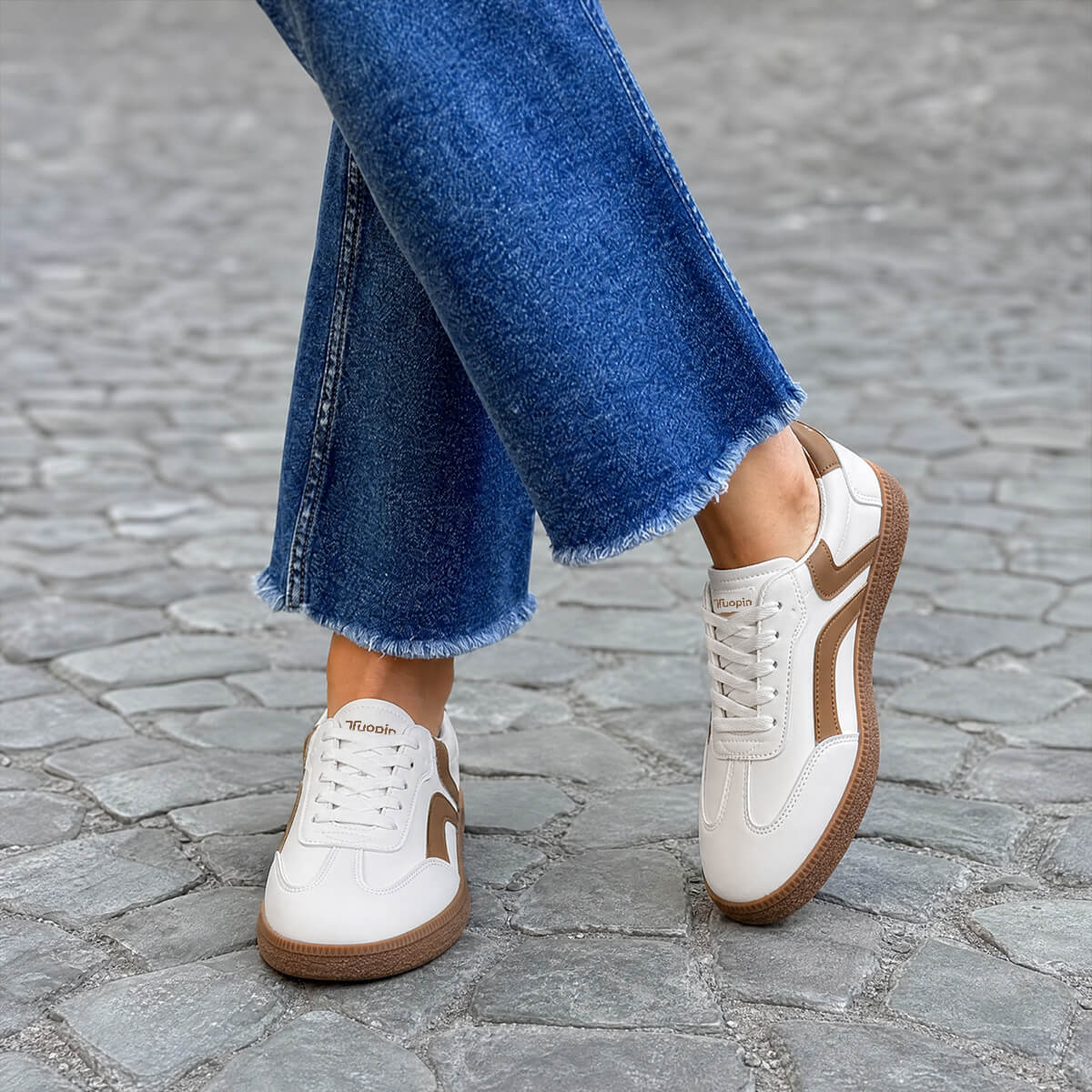 White and brown casual low-top sneakers worn with jeans