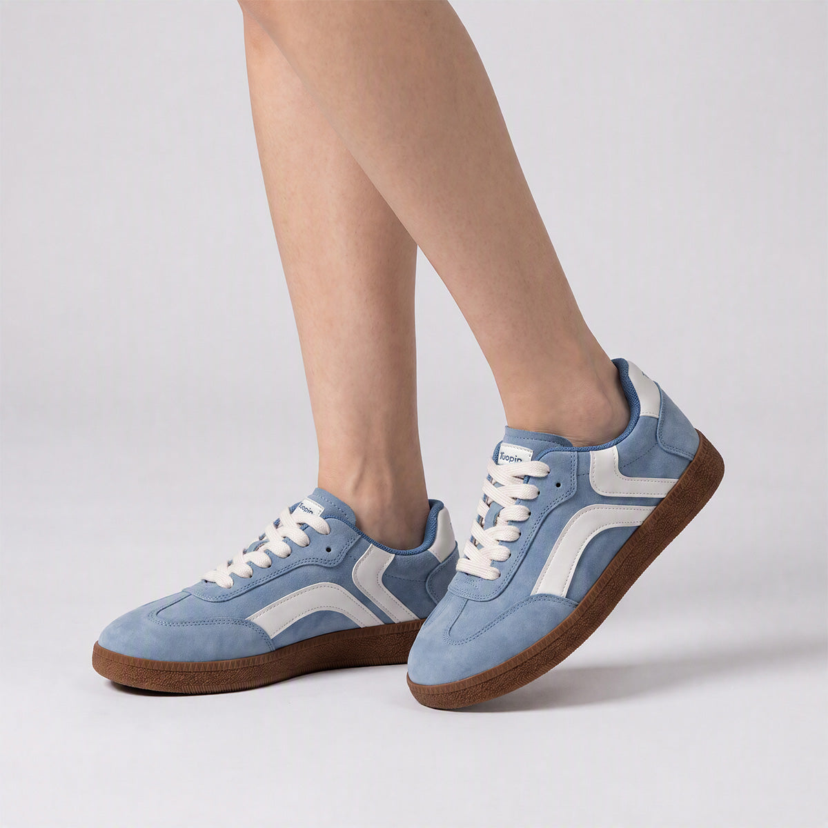 Sky blue and white casual low-top sneakers worn on foot
