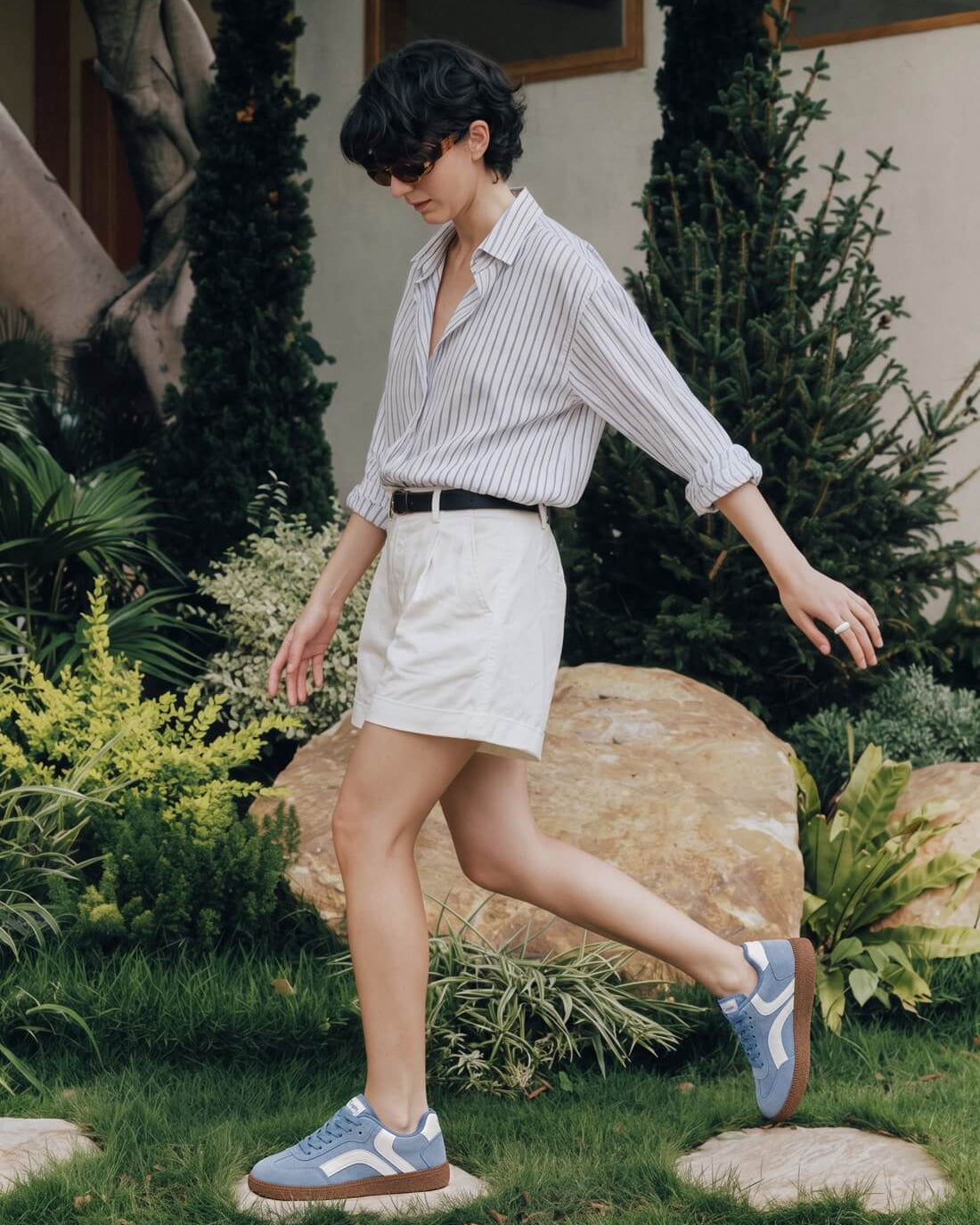Woman wearing blue Tuopin sneakers with a striped shirt and white shorts